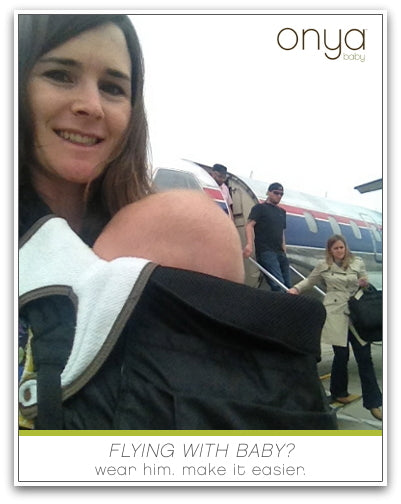 Mother with child in Onya Baby carrier boarding a plane