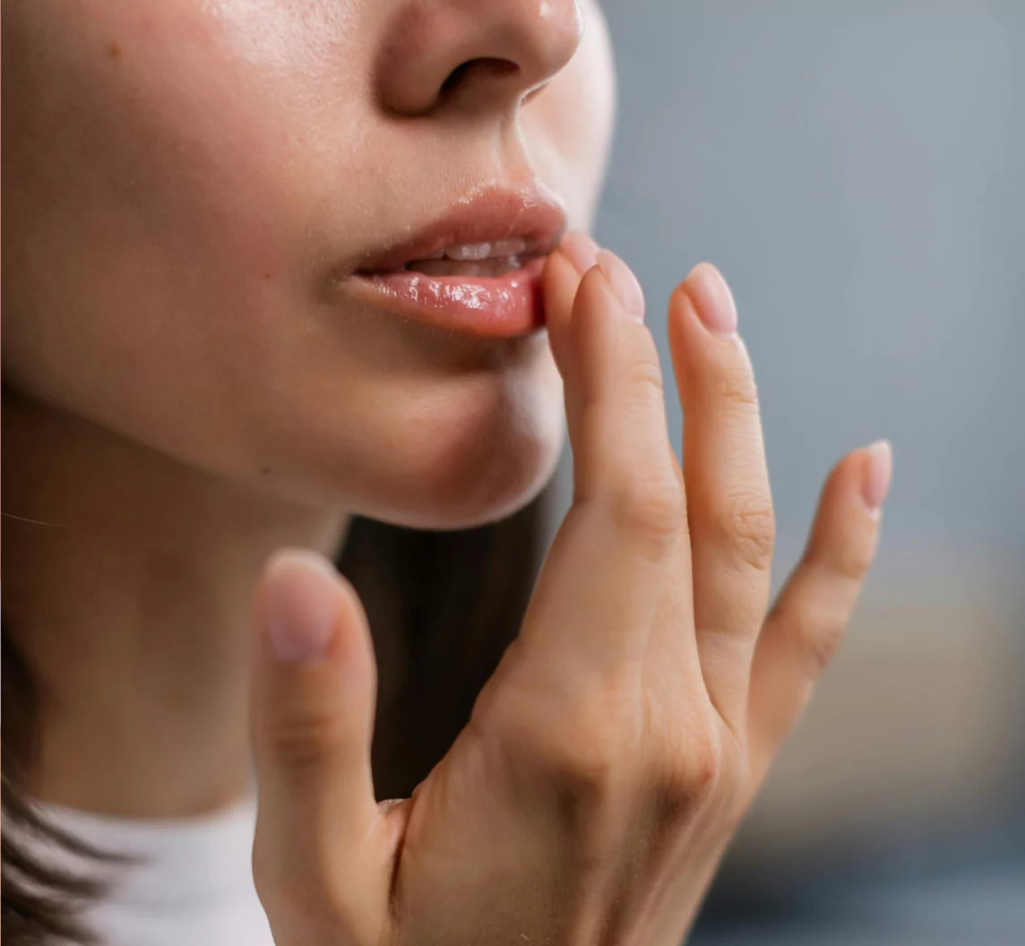 Close-up of a person applying lip balm with fingers.