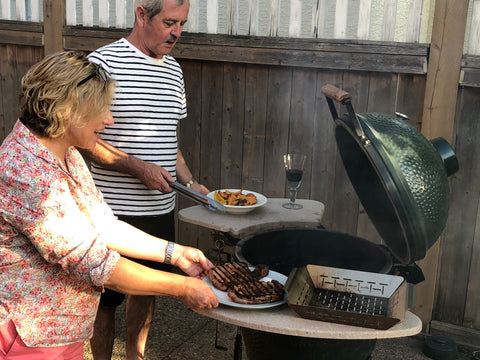 Charcoal Thin Blue Smoke from Big Green Egg Cooking Steaks and Potatoes and Couple Cooking on Charcoal BBQ