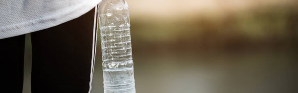 close up image of a woman exercising holding a water bottle