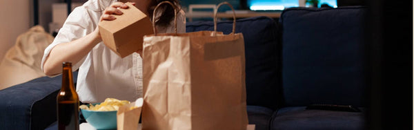 woman unpacking takeaway from a brown paper bag