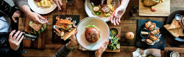 close up image of a table of friends eating out