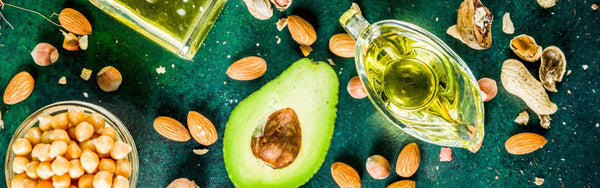 green table with avocado's, nuts and oils.