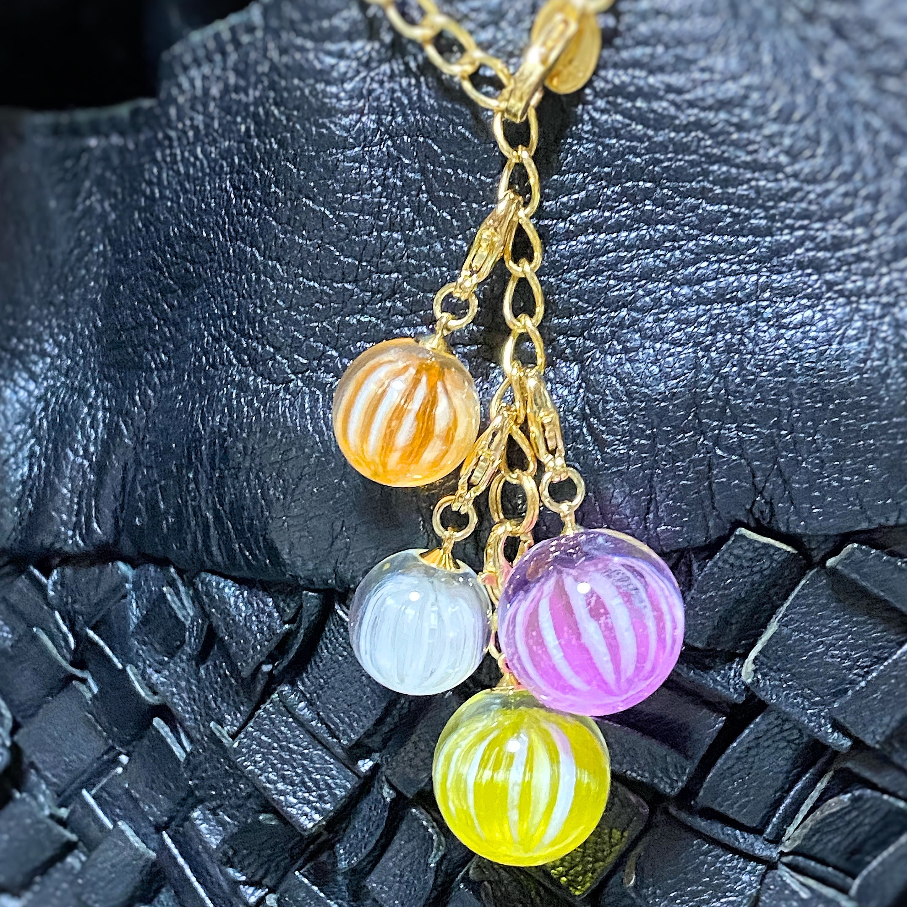 A combination of candy charms grape balls and lemon balls, candy charms small mandarin oranges and small yogurt, and a custom item bag charm chain.