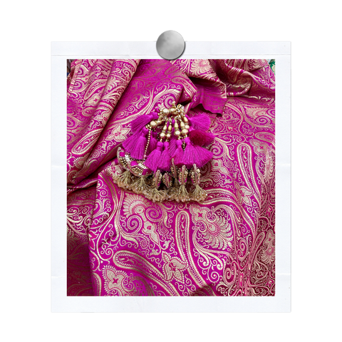 Pink Indian textile with a pink and gold tassle