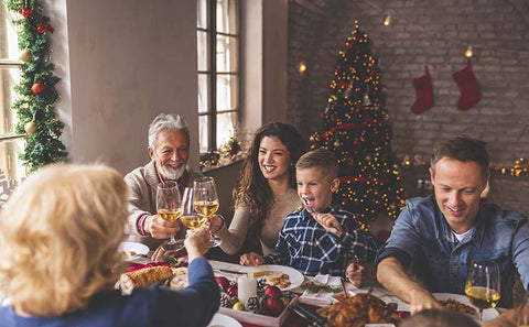 Family clinking wine at Christmas dinner