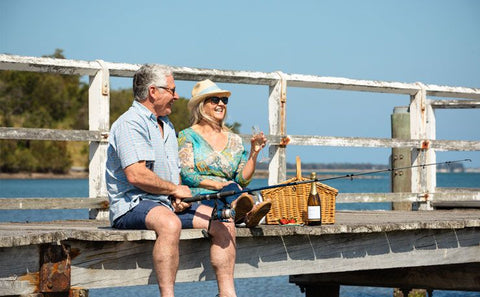 People fishing at a dock while drinking wine