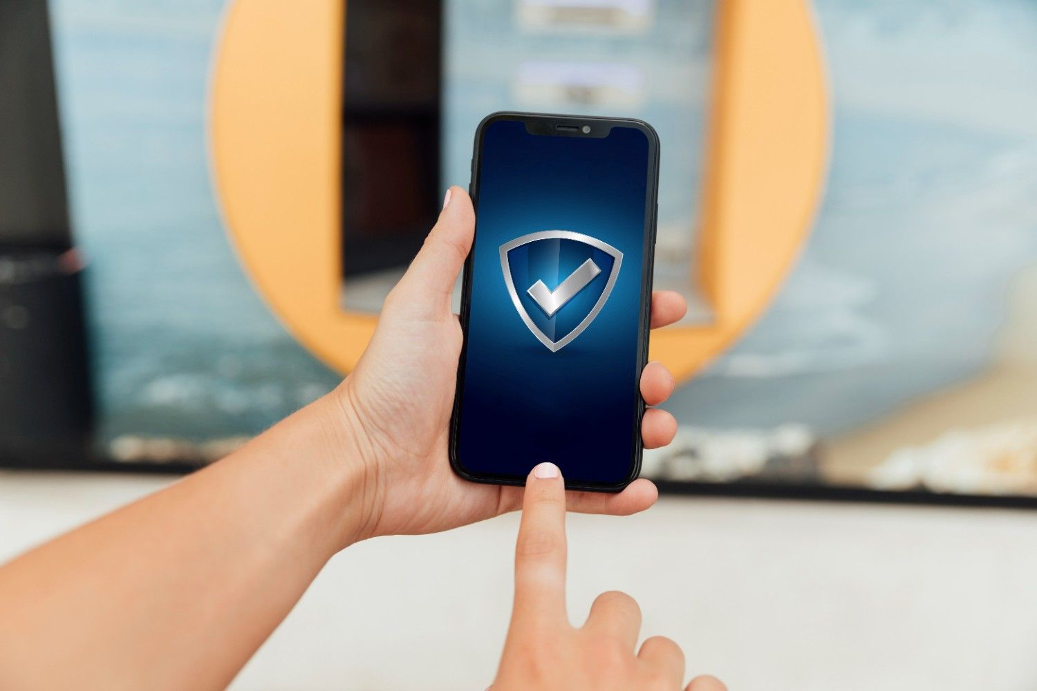 Hands holding smartphone with shield check icon, representing secure eSIM use for international travel.