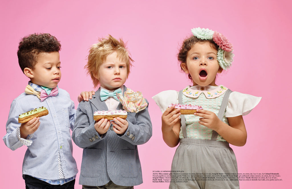 three kids standing with cakes in paade mode garments