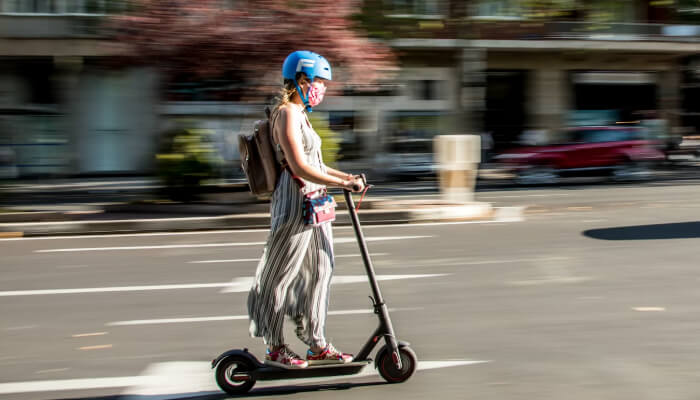 eine Dame auf einem E-Scooter