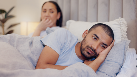 depressed man laying in bed