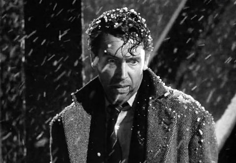 Jimmy Stewart portraying George Bailey in Its A Wonderful Life, seen with a tense expression while standing in the snow.