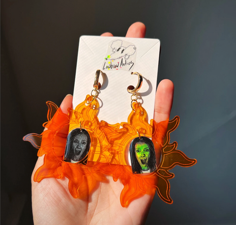 Handmade Hereditary Inspired Acrylic Earrings that feature a translucent orange flame with Toni Collette holographic film charm center.