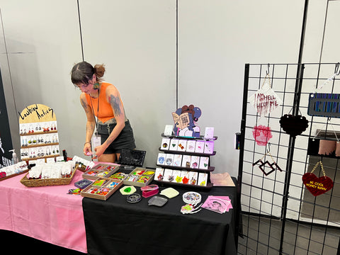 Lowbrow Antics creator Annalisa organizing product on a table at a show.