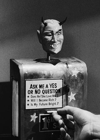 A fortune telling machine with a devil head on top.