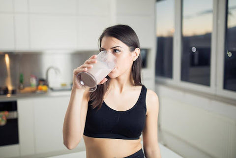A woman having a post-workout recovery drink.