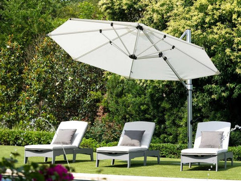 Chaise loungers under an umbrella on the lawn