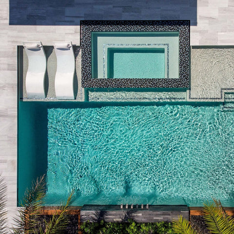 Overhead shot of pool with ledge, with two Ledge Loungers in-pool chaises with headrest pillows to the left of the ledge