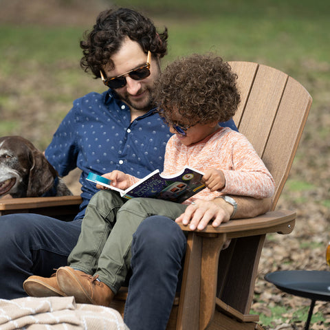 Father and son sitting together on a woodgrain Adirondack chair