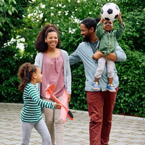 Family happily walking with a soccer ball
