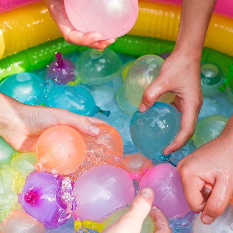 Hands grabbing filled water balloons for a competition