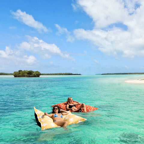 Relaxing on Laze Pillows in the ocean with the beach in the background