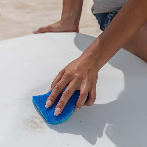 Cleaning outdoor furniture with a blue sponge