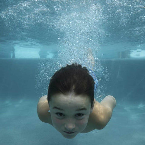 Child swimming underwater in pool