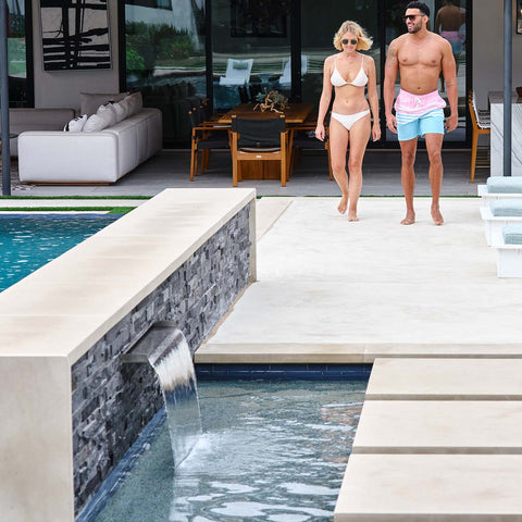 Couple walking out to pool with mini waterfall feature