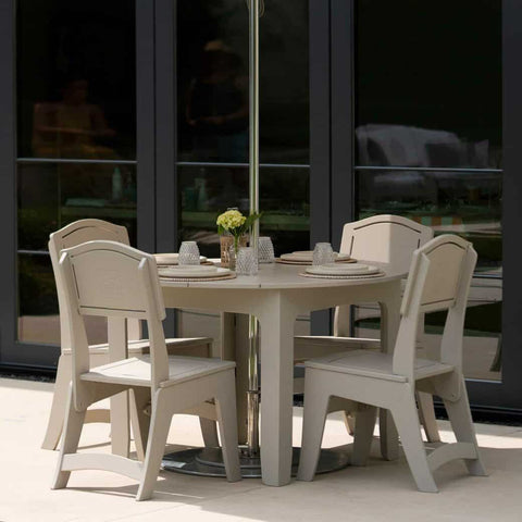 Dining table with umbrella pole and four dining chairs on patio