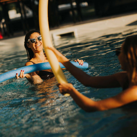 having a noodle jousting competition playing with pool noodles