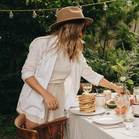 Woman setting drinks on a decorated table