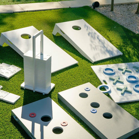 Ledge Loungers cornhole, washers, tic tac toe, and dominoes games on grass