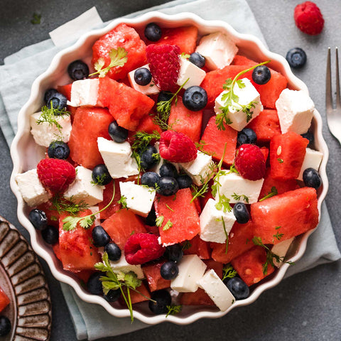 Bowl with watermelon, cheese, and other fruit salad ingredients