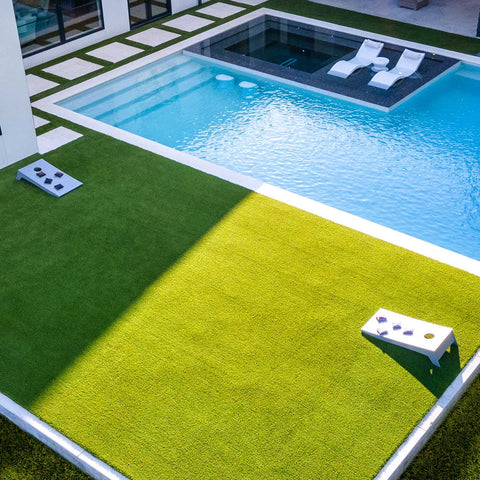 Yard with a couple of cornhole boards set up for a game