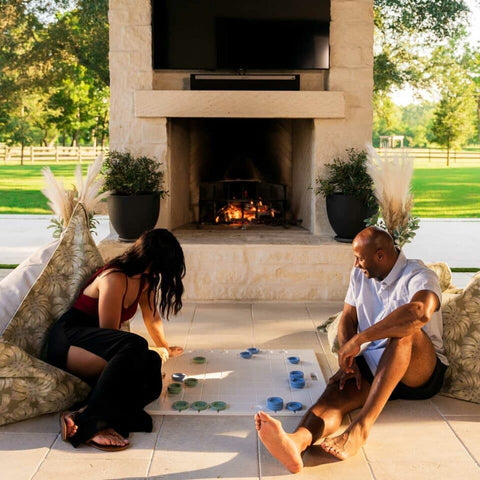 Couple playing checkers outside in front of a fire