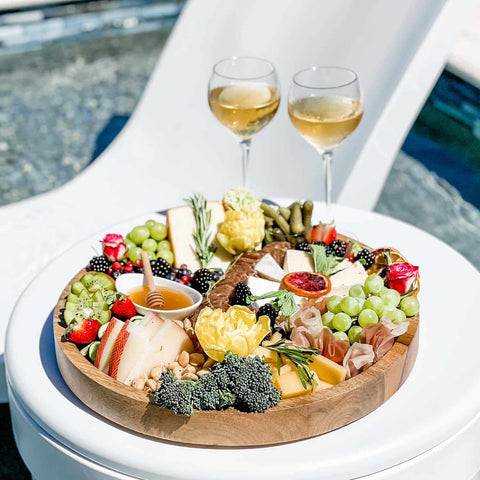 Charcuterie board and wine glasses on in-pool side table