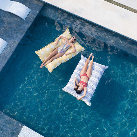 Women laying and floating on Laze Pillows in the pool