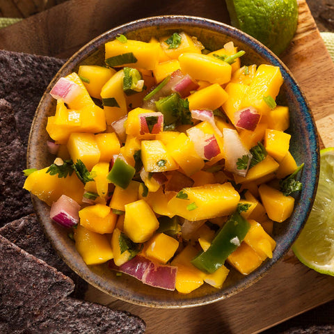 Mango and Pineapple in a bowl with jalapeños and red onion