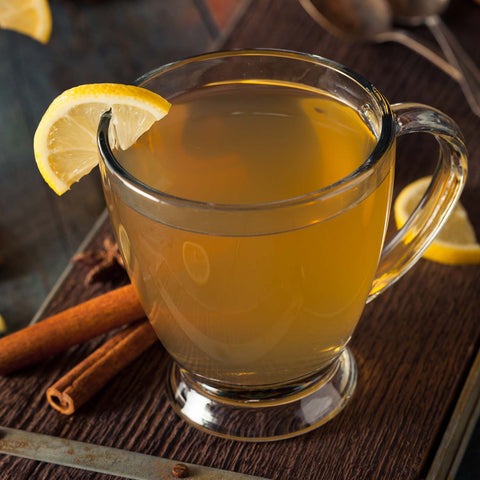 Hot toddy in a clear glass mug with lemon