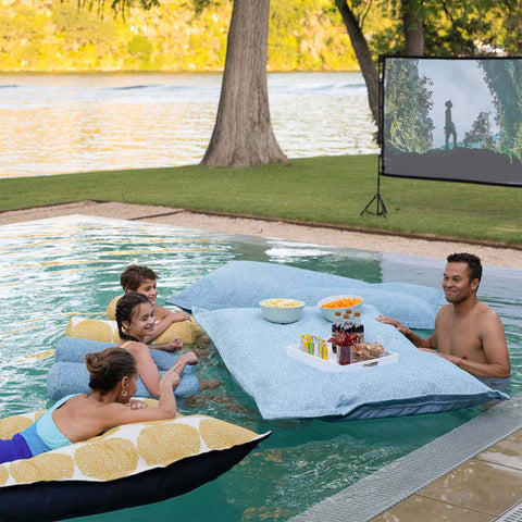 Enjoying a movie night inside the pool with popcorn and other snacks floating on Laze Pillow