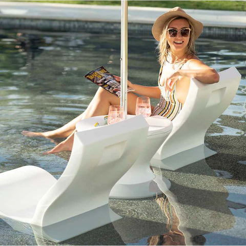 Woman sitting on in-pool chair with a magazine