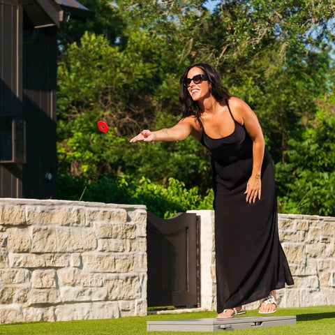 Woman in black maxi dress throwing a red washer