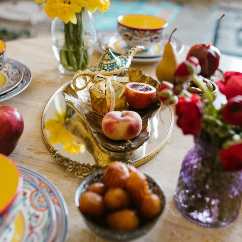 Moroccan table setting with whole fruits, reds, yellows and blues