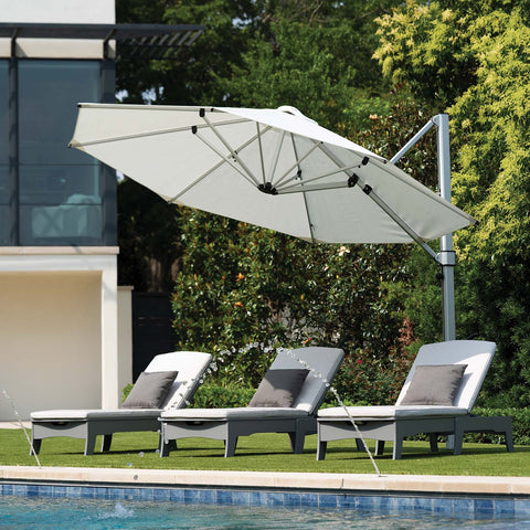 Echo Chaise Outdoor Chair under an umbrella on the lawn