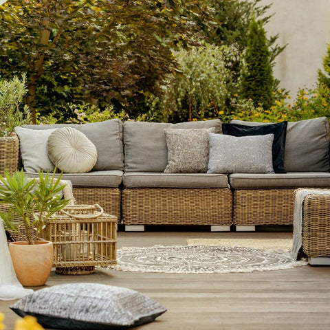 Wicker sectional with wicker coffee table in front of it, on a deck