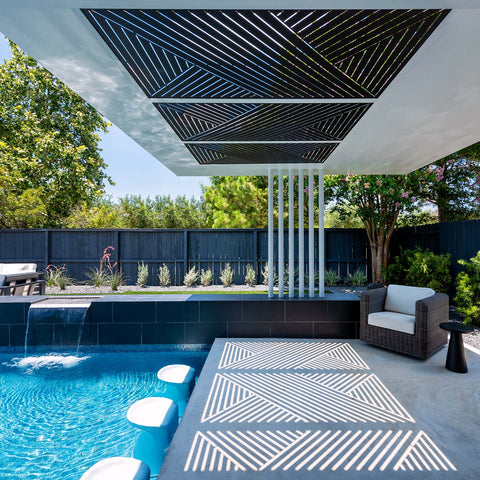 Outdoor space with in-pool barstools, lounge chairs, and a roof letting in patterned sunlight