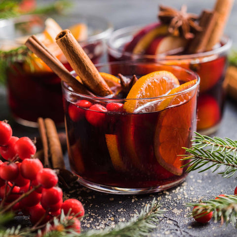 Mulled wine in a clear glass with cinnamon and fruit