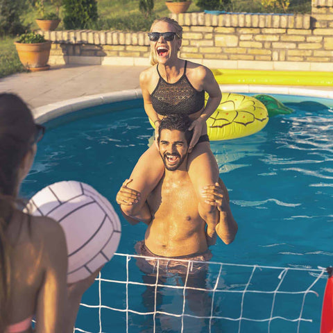 Couple playing volleyball in the pool