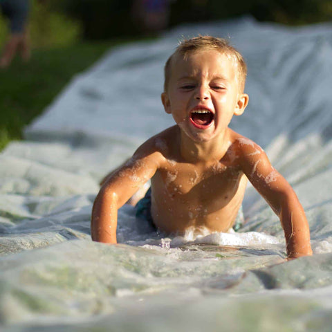 Kid enjoying a DIY slip and slide